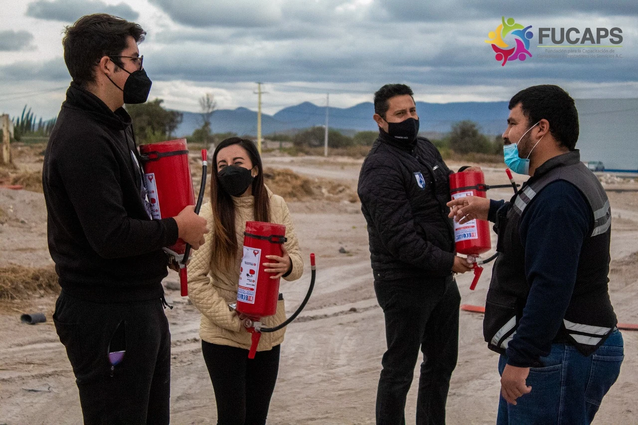 Un facilitador explica el uso de extintores a un grupo de participantes